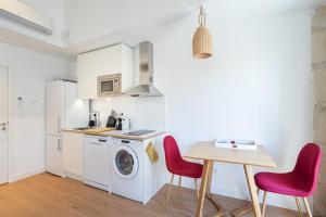 a kitchen with a washing machine and a table at La Palmeraie - Splendide coeur du Centre-Ville in Marseille