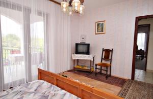 Sala de estar con cama y TV en Apartment Malinska 5284a en Malinska