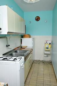 cocina con fregadero y fogones horno superior en Apartment Malinska 5284a en Malinska