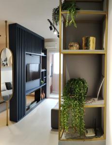 a living room with a shelf with a plant in it at Faça Tudo a Pé em Canela - LOFT in Canela