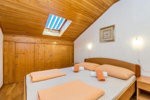 two beds in a room with a wooden ceiling at Apartments with a parking space Vantacici, Krk - 5313 in Malinska