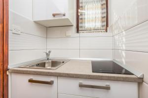 a white kitchen with a sink and a window at Apartments with a parking space Vantacici, Krk - 5313 in Malinska +35 photos