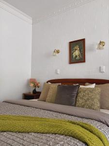 Victoria House Motor Inn في كرويدون: غرفة نوم بسرير كبير مع بطانية خضراء