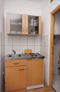 a small kitchen with a sink and a stove at Apartments and rooms with parking space Sveti Vid, Krk - 5323 in Sveti Vid-Miholjice