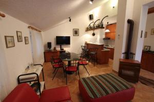 a living room with a table and chairs and a kitchen at Apartments by the sea Malinska (Krk) - 5290 in Vantačići