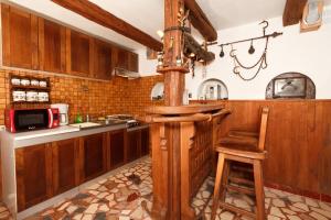 a kitchen with a wooden bar with a wooden stool at Apartments by the sea Malinska (Krk) - 5290 in Vantačići