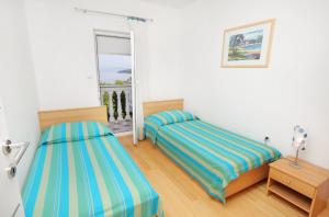 a bedroom with two beds and a window at Apartments by the sea Njivice, Krk - 5296 in Njivice