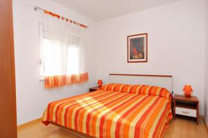 a white bedroom with a bed and a window at Apartments by the sea Njivice, Krk - 5295 in Njivice
