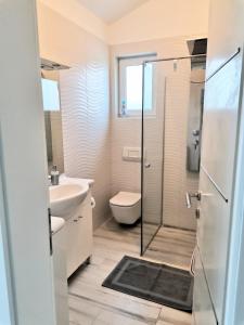W łazience znajduje się prysznic, toaleta i umywalka. w obiekcie Apartments by the sea Njivice, Krk - 5295 w mieście Nijvice