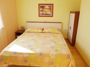 a bedroom with a bed with a floral bedspread at Apartment Njivice 5295b in Njivice
