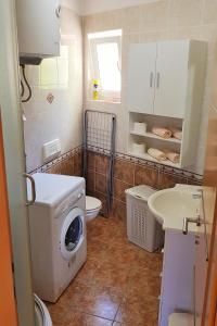 a bathroom with a washing machine and a sink at Apartment Njivice 5295b in Njivice