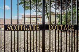 un cancello con le parole "scotateateateateenceence" di Cottage In Norfolk Sleeps 23 - Private Pool, Fishing Lake, Hot Tub Ref 99008sc a Hockham