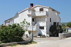 a large white building on the side of a road at Apartments and rooms with parking space Krk - 5294 in Krk