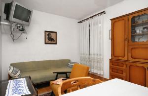 a living room with a couch and a tv at Apartments with a parking space Baska, Krk - 5411 in Baška