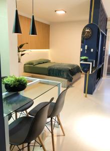 a bedroom with a bed and a glass table and chairs at Faça Tudo a Pé em Canela - LOFT in Canela
