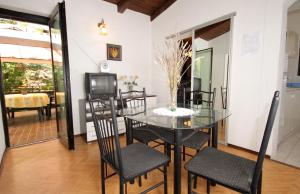 jadalnia ze szklanym stołem i krzesłami w obiekcie Apartments with a parking space Artatore, Losinj - 5377 w mieście Čunski