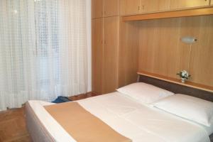 a bedroom with a bed and a window at Apartments with a parking space Selce, Crikvenica - 5495 in Selce