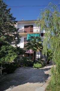 an apartment building with a balcony and a palm tree at Apartments with a parking space Selce, Crikvenica - 5495 in Selce