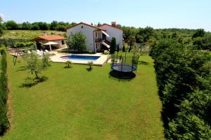 a yard with a pool and a house at Family friendly apartments with a swimming pool Strmac, Labin - 5527 in Strmac