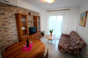 a living room with a table and a couch at Family friendly apartments with a swimming pool Strmac, Labin - 5527 in Strmac