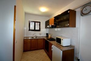 a small kitchen with a microwave on a counter at Family friendly apartments with a swimming pool Strmac, Labin - 5527 in Strmac