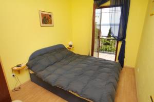 a bedroom with a bed in a room with a window at Apartments by the sea Dramalj, Crikvenica - 5522 in Dramalj