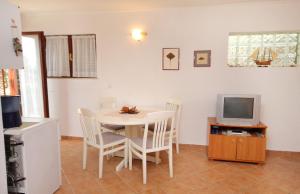 a dining room with a table and a television at Apartments by the sea Dramalj, Crikvenica - 5522 in Dramalj