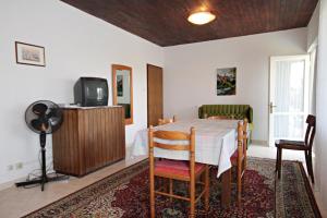 Apartment Krk 5318a في كرك: غرفة طعام مع طاولة وتلفزيون في غرفة