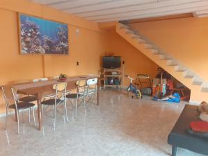 una sala da pranzo con tavolo, sedie e scala di La Candela 1 casa a Villa Lonca