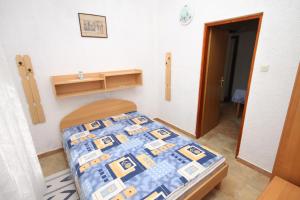 a bedroom with a bed with a blue and yellow quilt at Apartments with a parking space Pinezici, Krk - 5319 in Pinezici