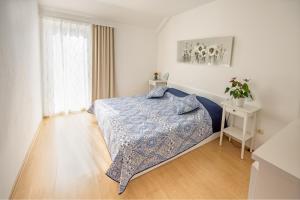 a white bedroom with a bed and a window at Apartments with a parking space Njivice, Krk - 5427 in Njivice