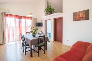 a dining room with a table and chairs and a couch at Apartments with a parking space Njivice, Krk - 5427 in Njivice
