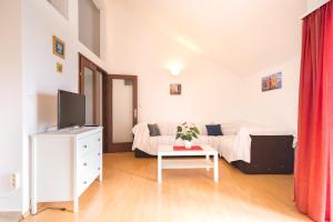 a living room with a couch and a table with a tv at Apartments with a parking space Njivice, Krk - 5427 in Njivice