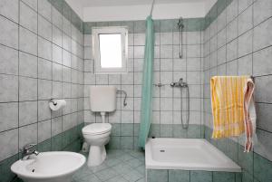 łazienka z wanną, toaletą i umywalką w obiekcie Apartments with a parking space Njivice, Krk - 5427 w mieście Nijvice +27 zdjęć