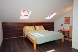 een slaapkamer met een bed met een houten hoofdeinde en dakramen bij Apartments by the sea Krk - 5400 in Krk