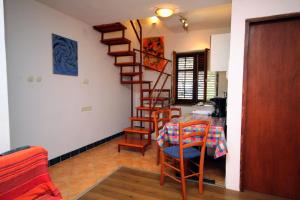 a room with a table and a spiral staircase at Apartments by the sea Krk - 5400 in Krk