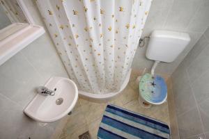 a bathroom with a toilet and a sink and a shower curtain at Apartments by the sea Krk - 5400 in Krk