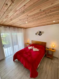 een slaapkamer met een groot rood bed en houten plafonds bij La kaz 57 - Maison avec SPA privatif in La Plaine des Palmistes