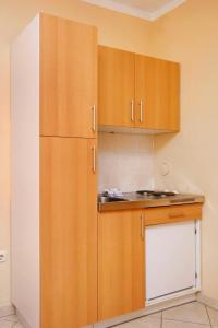 a kitchen with wooden cabinets and a refrigerator at Studio Baska 5450b in Baška