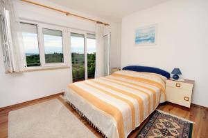 a bedroom with a bed and a window at Apartments and rooms by the sea Dramalj, Crikvenica - 5519 in Dramalj