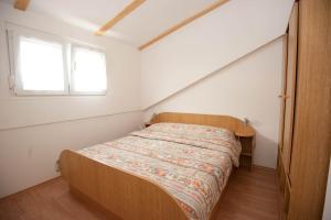 a bedroom with a bed in a room with a window at Apartment Njivice 5398a in Njivice
