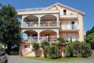 a large house with balconies and trees in front of it at Apartment Njivice 5398h in Njivice