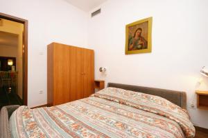 a bedroom with a bed and a painting on the wall at Apartment Njivice 5398h in Njivice
