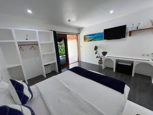a bedroom with a bed and a tv on the wall at Secret paradise moalboal in Moalboal