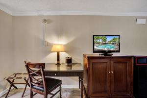 Habitación con escritorio, TV y silla. en Fort Lauderdale Grand Hotel en Fort Lauderdale