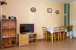 a living room with a television and a table with chairs at Apartments with a parking space Kornic, Krk - 5306 in Kornić