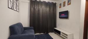 Flat Home Practice في ساو لويس: غرفة معيشة مع كرسي أزرق وتلفزيون