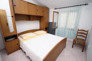 1 dormitorio pequeño con 1 cama y 1 silla en Apartments by the sea Businci, Ciovo - 5256 en Trogir