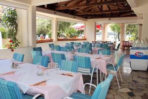 a dining room with tables and chairs and windows at Apartments by the sea Punat, Krk - 5328 in Punat