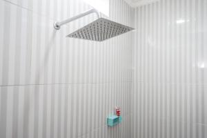 een badkamer met een douche met een licht aan de muur bij RedDoorz near Rita Supermall Purwokerto 2 in Purwokerto